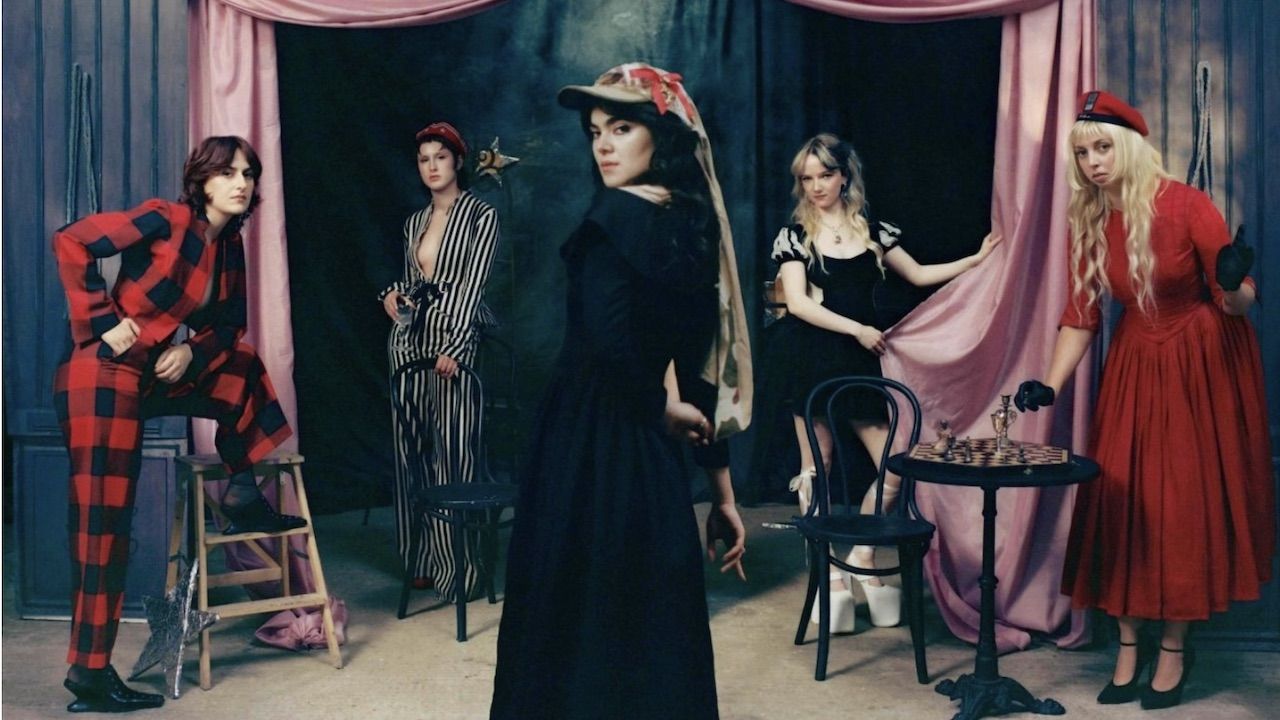 “Lyrics invoke rifles, scythes, sailors, saints, cowboys, floods, Mother Earth, Joan of Arc, and blazing infernos.” The Last Dinner Party announce second album From The Pyre, share dark, dramatic new single This Is The Killer Speaking