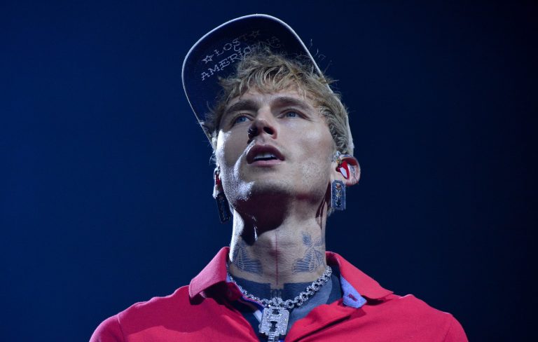 Watch MGK “mess my back up really, really bad” as he somersaults off roof into audience