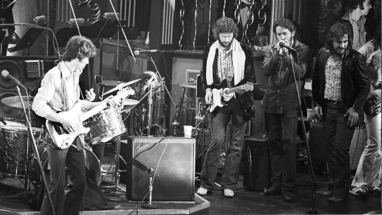 “The whole song turned into kind of a guitar dialogue.” Watch the historic footage of Robbie Robertson saving Eric Clapton before they go head-to-head in a duel for the ages